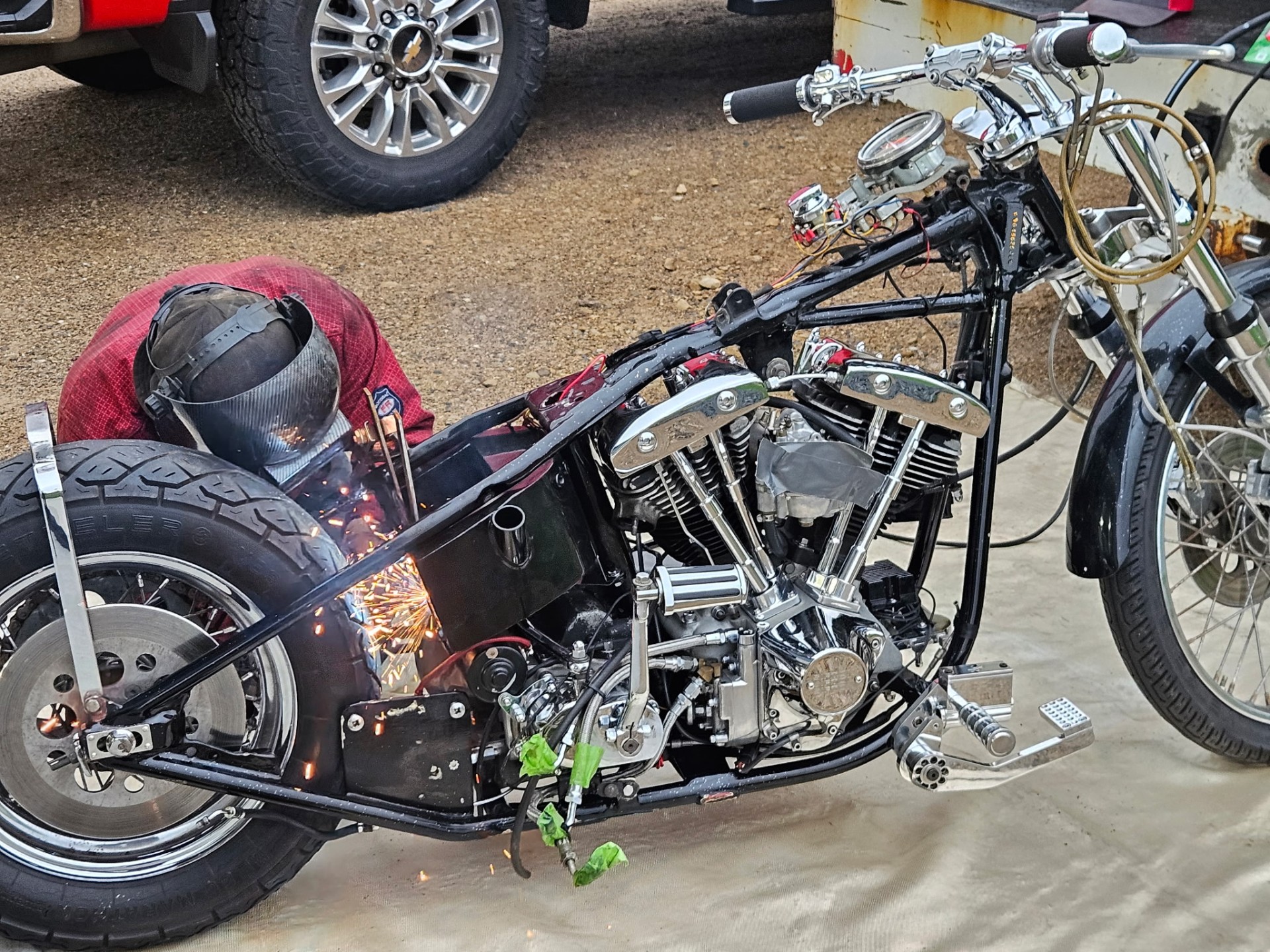 Welder TIG welding a custom chopper frame on-site